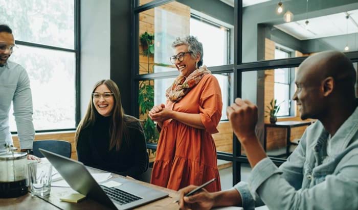 A smiling group of people meeting in an office